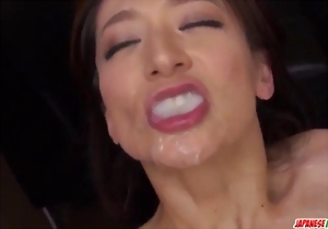 A cute-looking Asian babe is getting her face fucked by a big penis